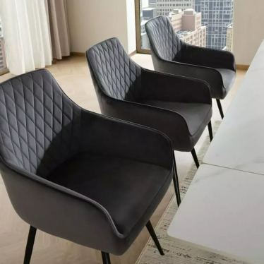 Trio de chaises pivotantes Lotinda noires installées autour d'une table blanche