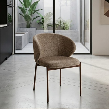 Chaise Elora en tissu beige installée dans un salon moderne avec sol en béton