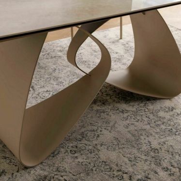 Détail du pied central en métal cachemire de la table AMBRE, aux courbes en forme d'infini