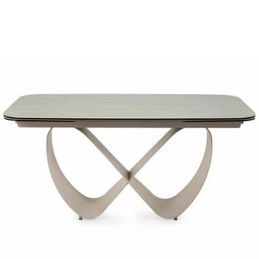 Table AMBRE vue de face en légère plongée, plateau en céramique et base métallique aux courbes entrelacées
