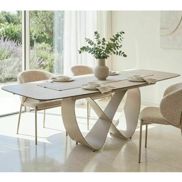Table à manger AMBRE dans une salle à manger lumineuse près de grandes fenêtres, entourée de chaises claires