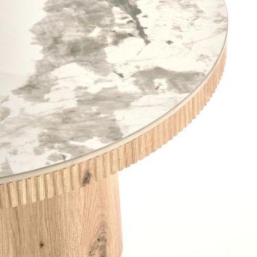 Gros plan sur le veinage gris du plateau effet marbre et la ceinture cannelée de la table Magus